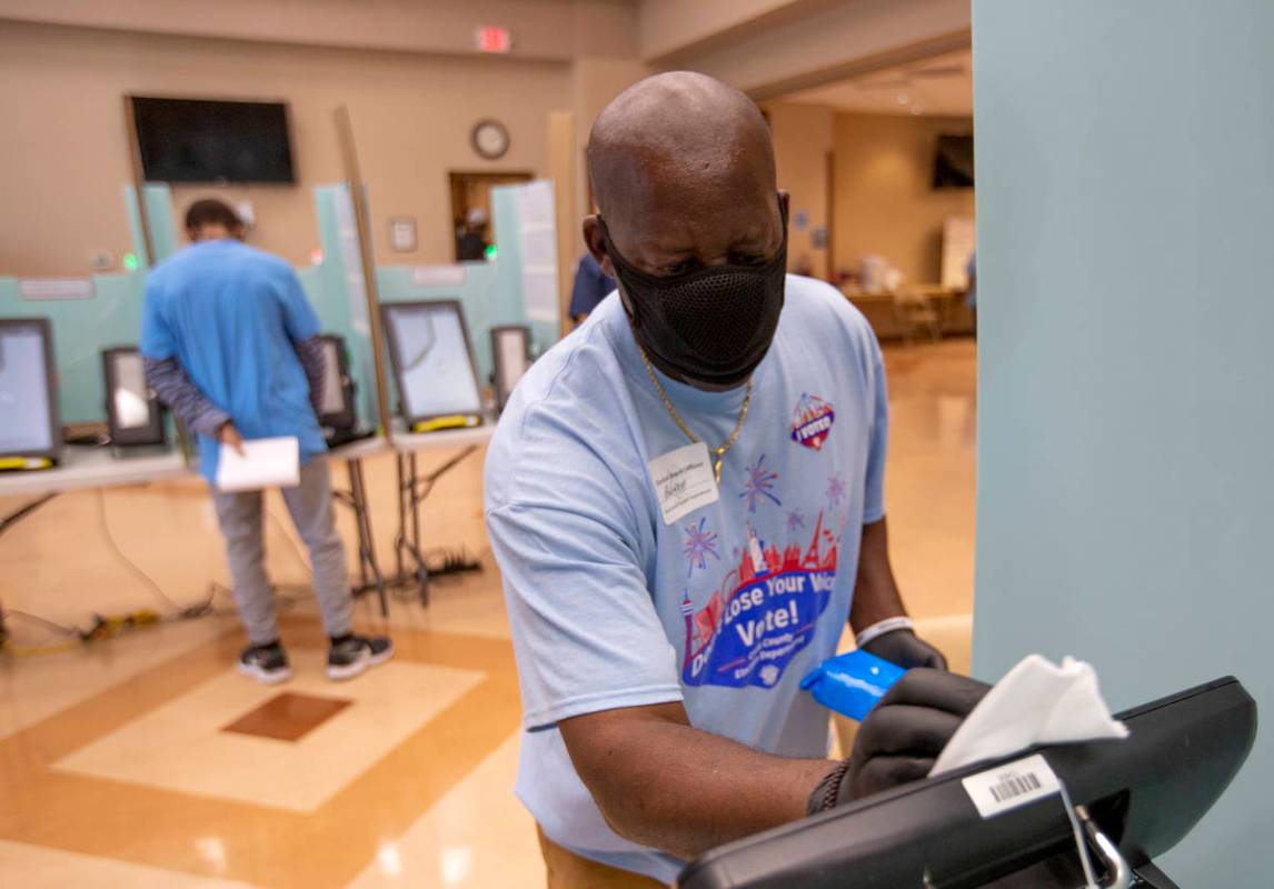 Rodney Jefferson limpia una máquina de votación en el Doolittle Community Center durante la v ...