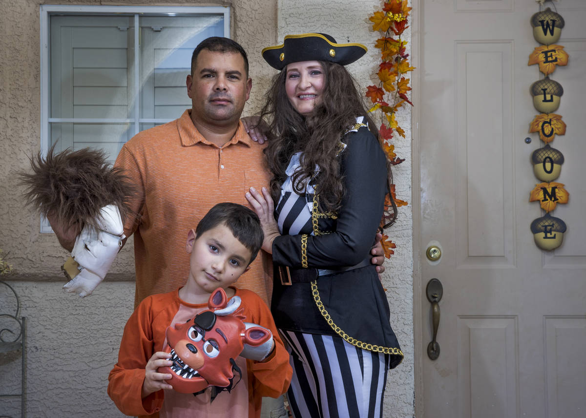 Alex Montenegro, de ocho años, con sus padres Joe y Kim Cabrero disfrazados en su casa decorad ...