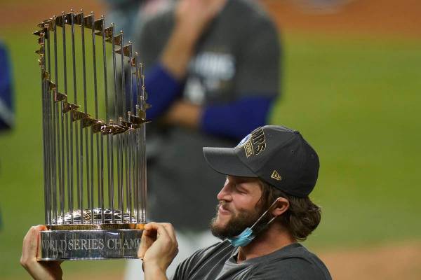 El lanzador de los Dodgers de Los Ángeles, Clayton Kershaw, celebra con el trofeo después de ...