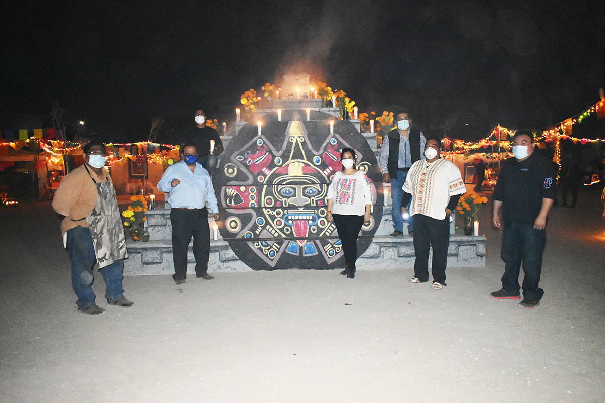 Miembros de la Comunidad Migrante Las Vegas posan para una foto frente a un altar conmemorativo ...
