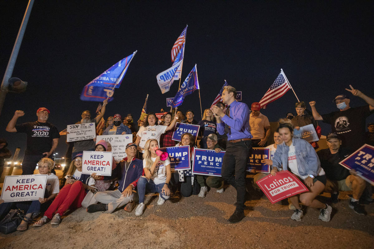 Partidarios del presidente Donald Trump posan para una foto mientras protestan fuera del edific ...