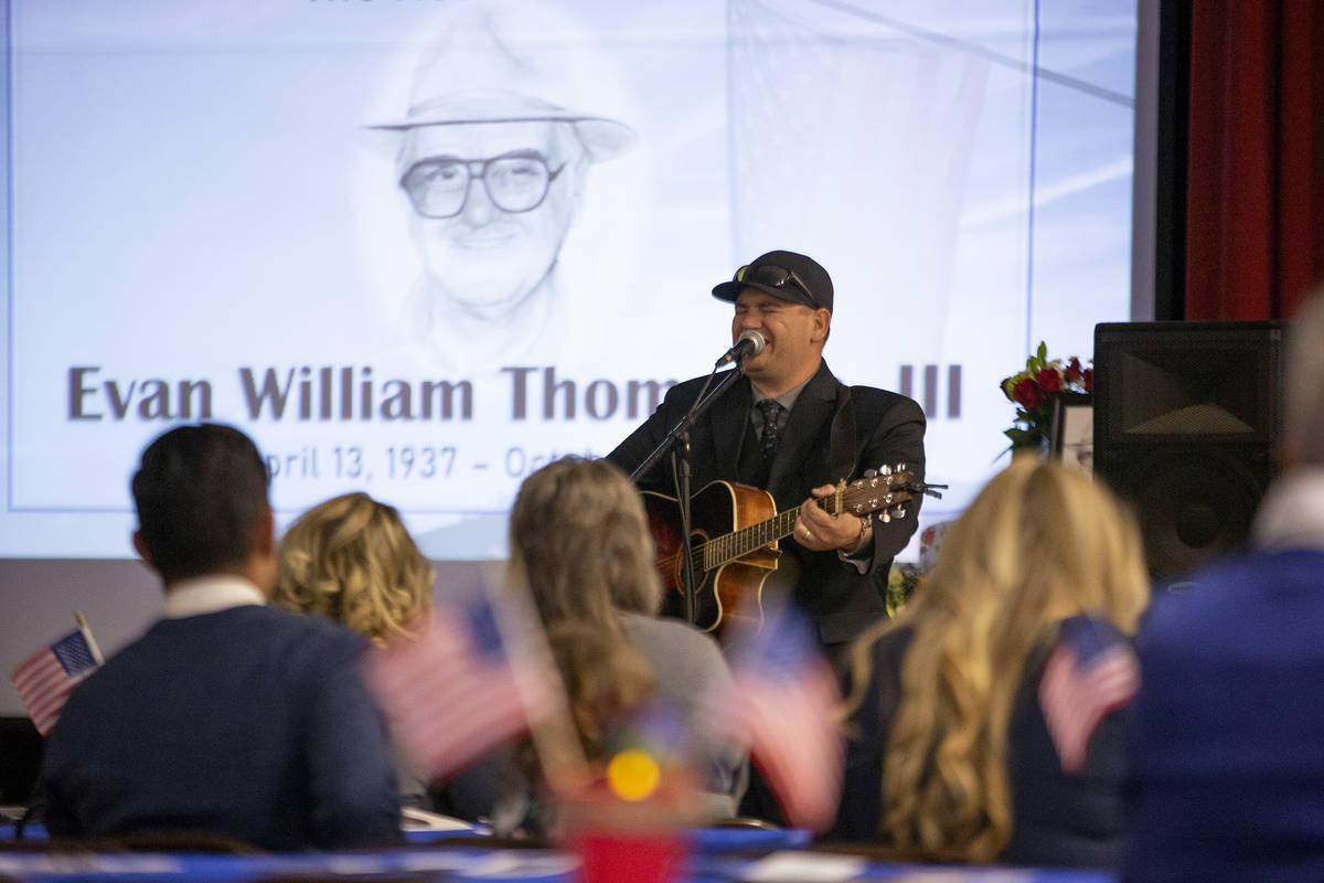 Elan Thompson, hijo del veterano de la Marina, Evan Thompson III, canta una canción durante el ...
