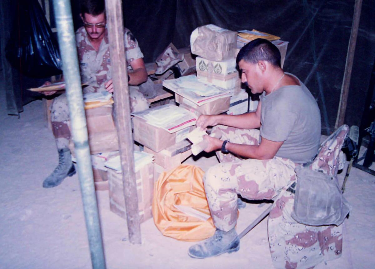 First Sergeant Alfred Ferryerra sorts stacks of mail sent to soldiers at the start of Desert Sh ...