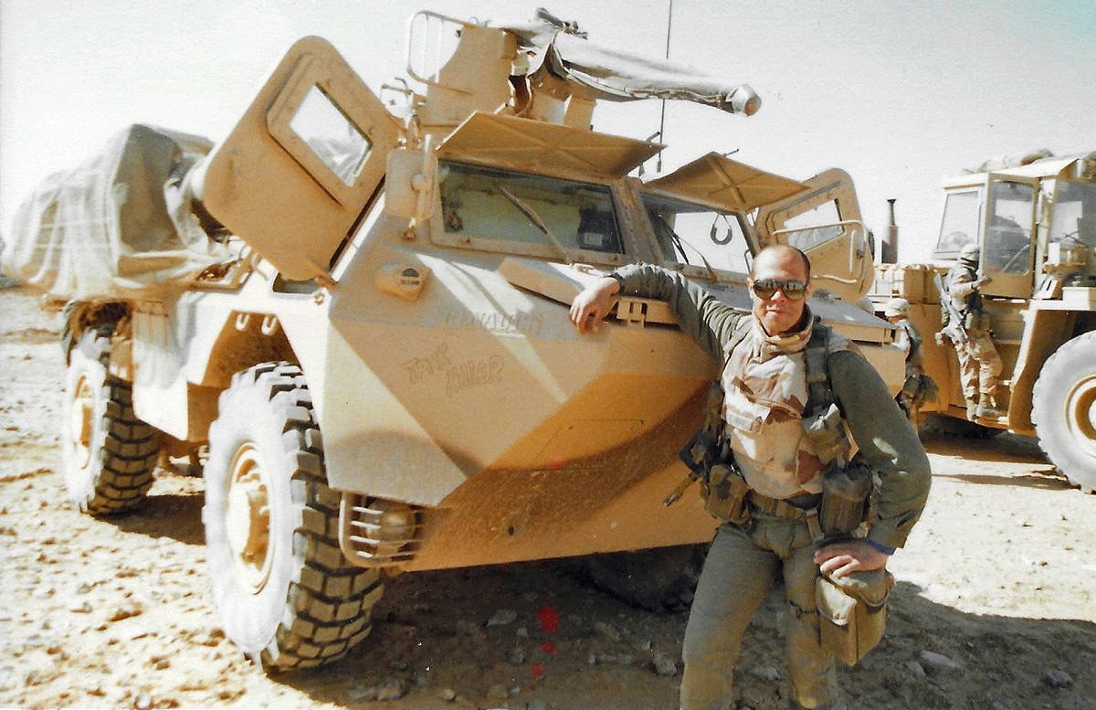 A French Soldier proudly poses with his light armored vehicle and its 25mm Bushmaster main gun ...
