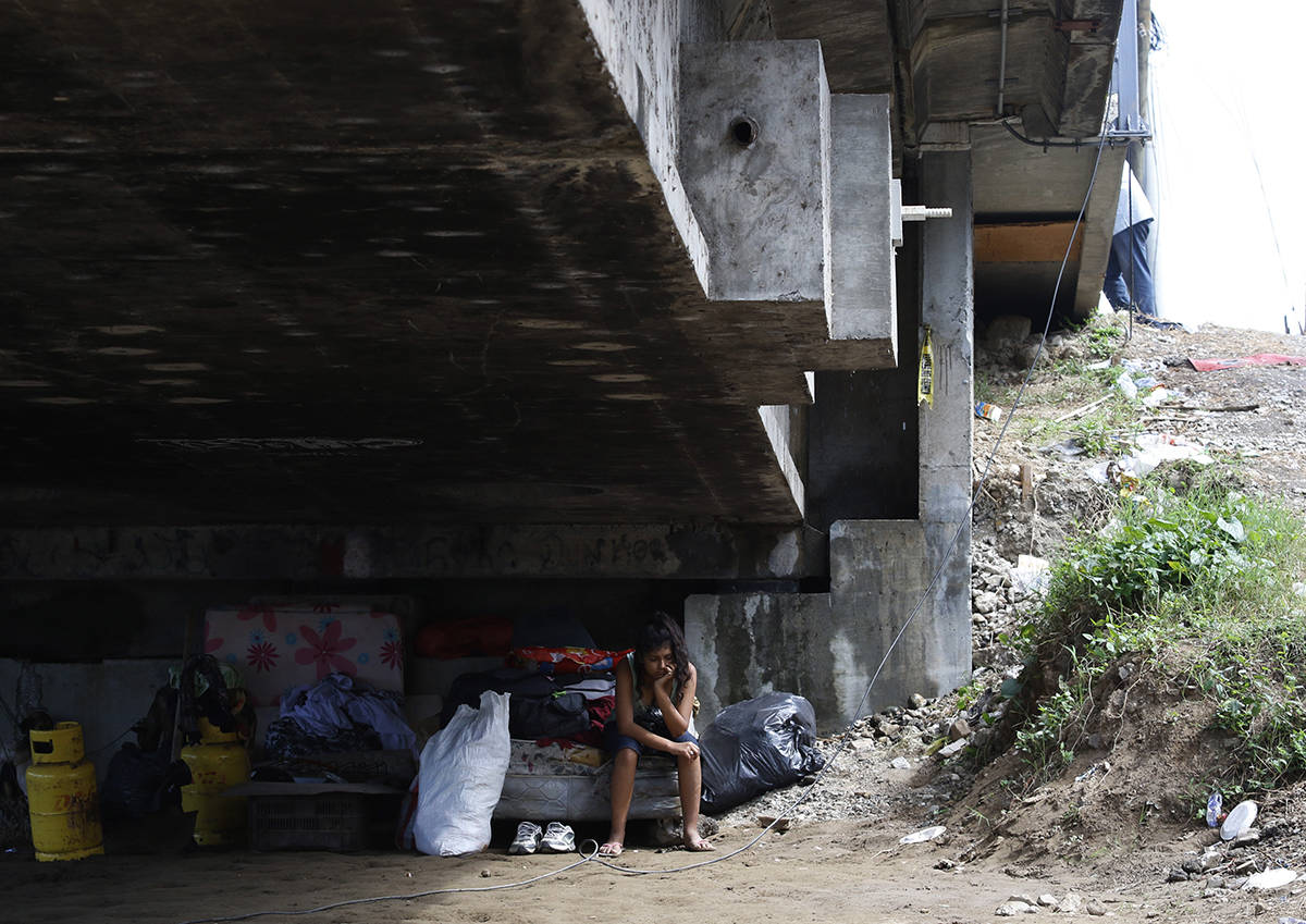 Mileydi Duarte, quien fue evacuada hoy por su familia, descansa debajo de un puente de la carre ...