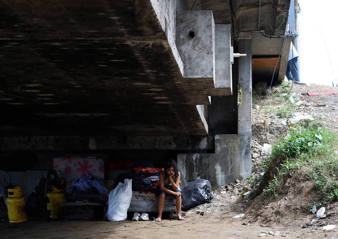Mileydi Duarte, quien fue evacuada hoy por su familia, descansa debajo de un puente de la carre ...
