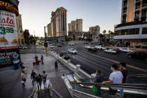 La gente toma una escalera mecánica a un puente peatonal sobre Flamingo Road en Las Vegas Stri ...