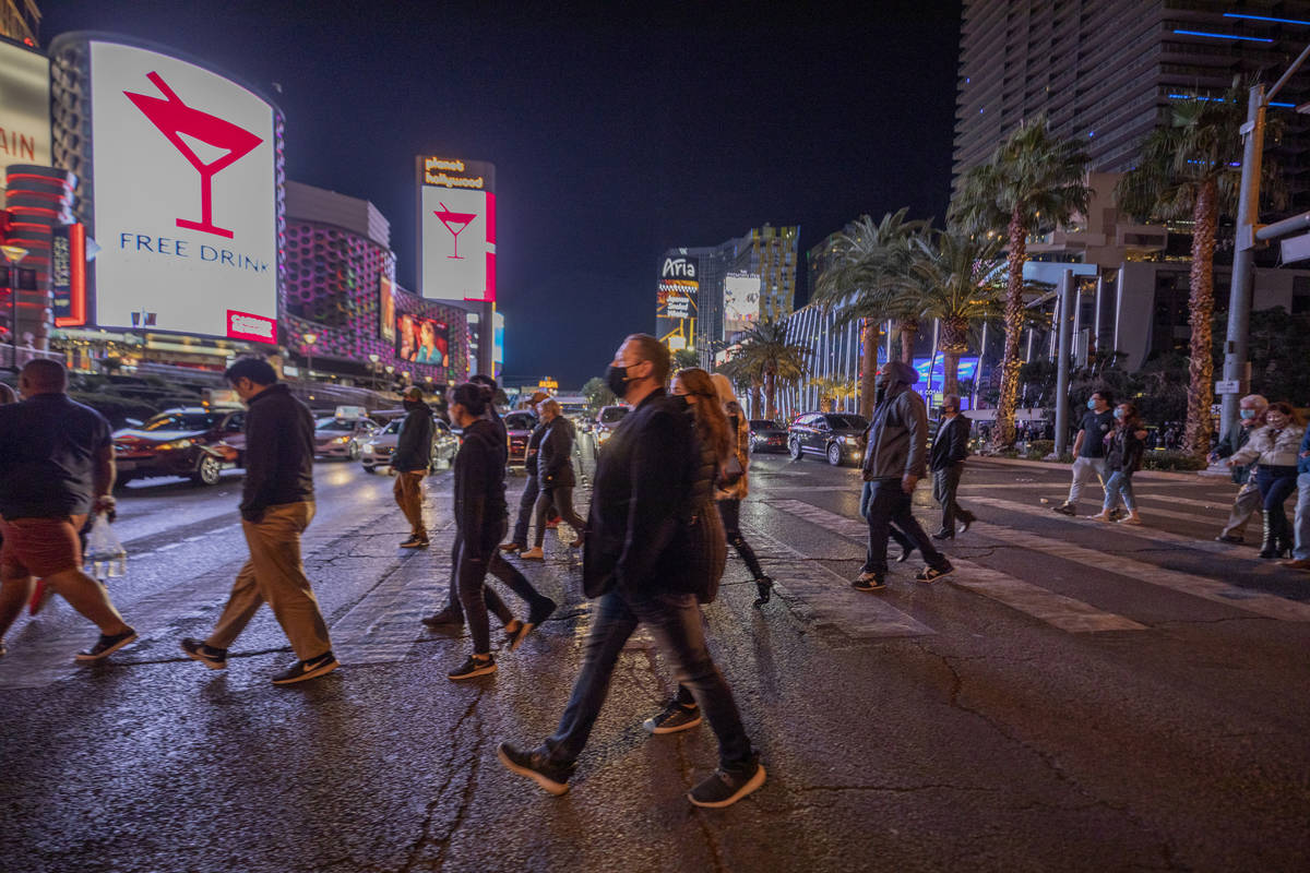 Tourists walk across Las Vegas Blvd., on the Strip, Friday, Nov. 27, 2020, in Las Vegas. (Eliza ...