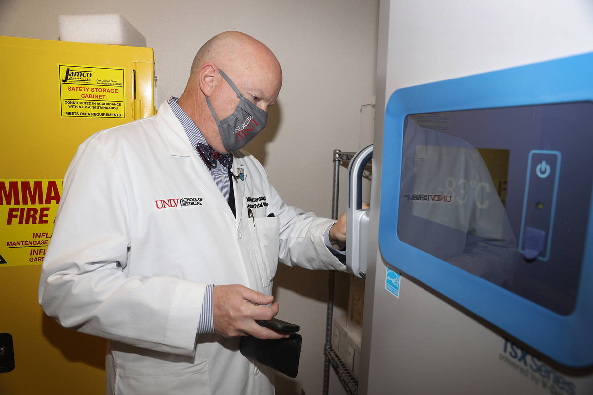 El doctor Michael Gardner abre un congelador que se utilizará para almacenar vacunas contra CO ...