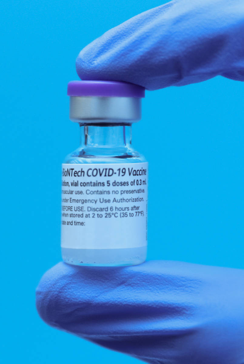 Un empleado del Centro Médico Universitario muestra la vacuna de COVID-19 el lunes, 14 de dici ...