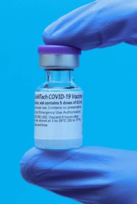 Un empleado del Centro Médico Universitario muestra la vacuna de COVID-19 el lunes, 14 de dici ...