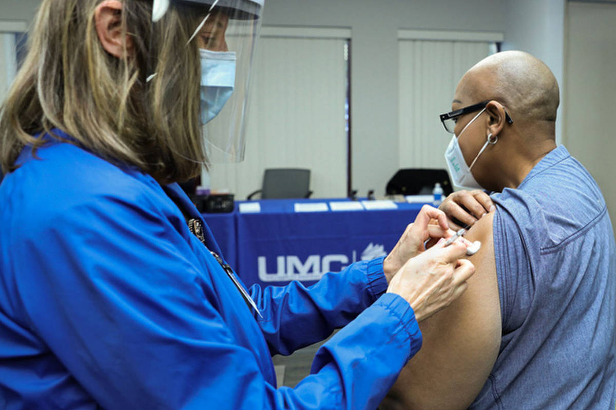 La enfermera de salud del University Medical Center, Lori Conti, administra una vacuna contra C ...