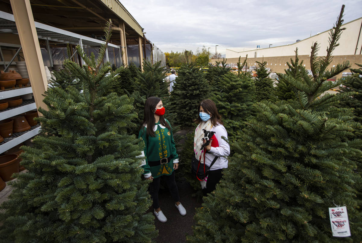Maddy Chatham, a la izquierda, compra un árbol de Navidad con su madre, Lisa Chatham, y su per ...