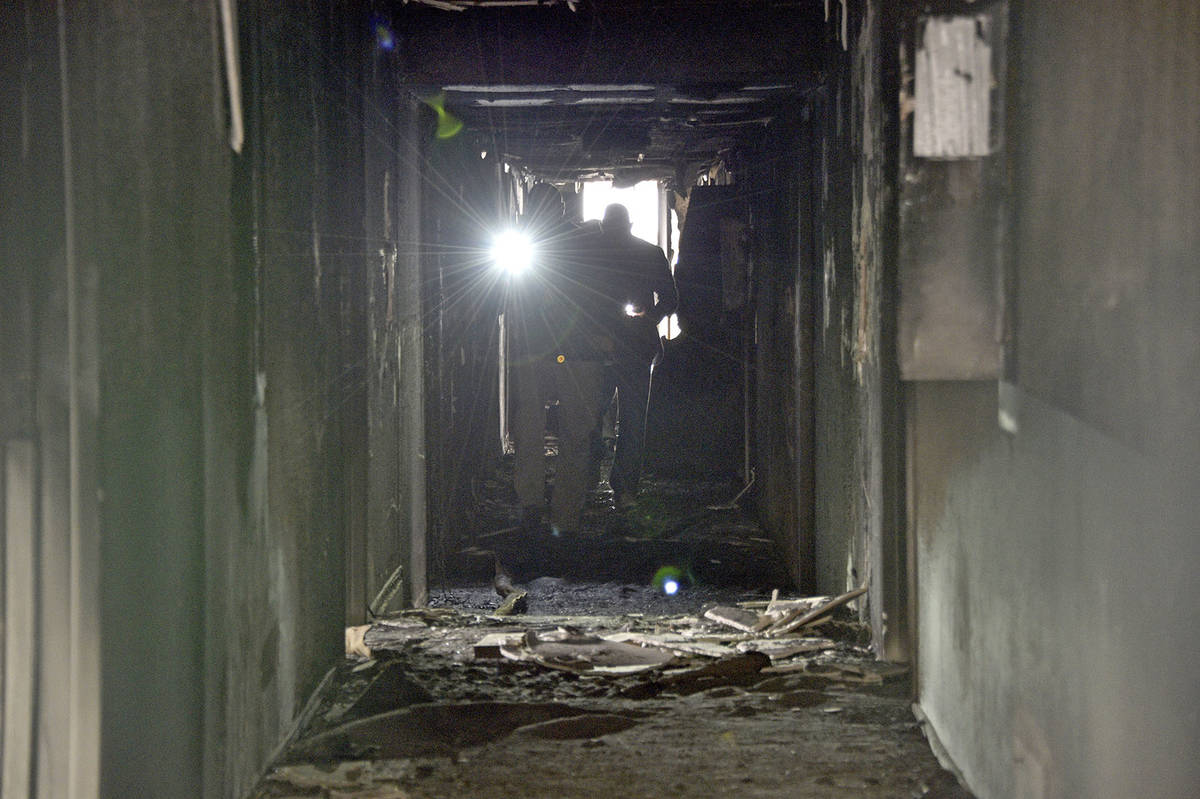 Investigadores caminan por un corredor interior el 21 de diciembre de 2019 después de un incen ...