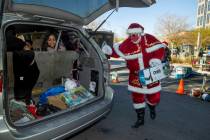 Santa Claus carga regalos durante el primer evento "NLVPD Holiday Toy Giveaway" en el estaciona ...