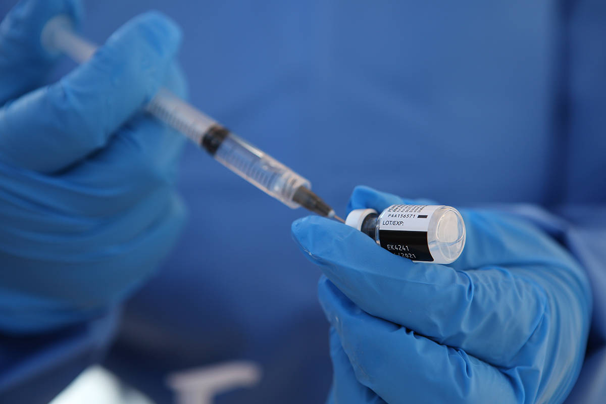 Un trabajador de salud extrae una dosis de la vacuna COVID-19 en la base militar de Querétaro, ...