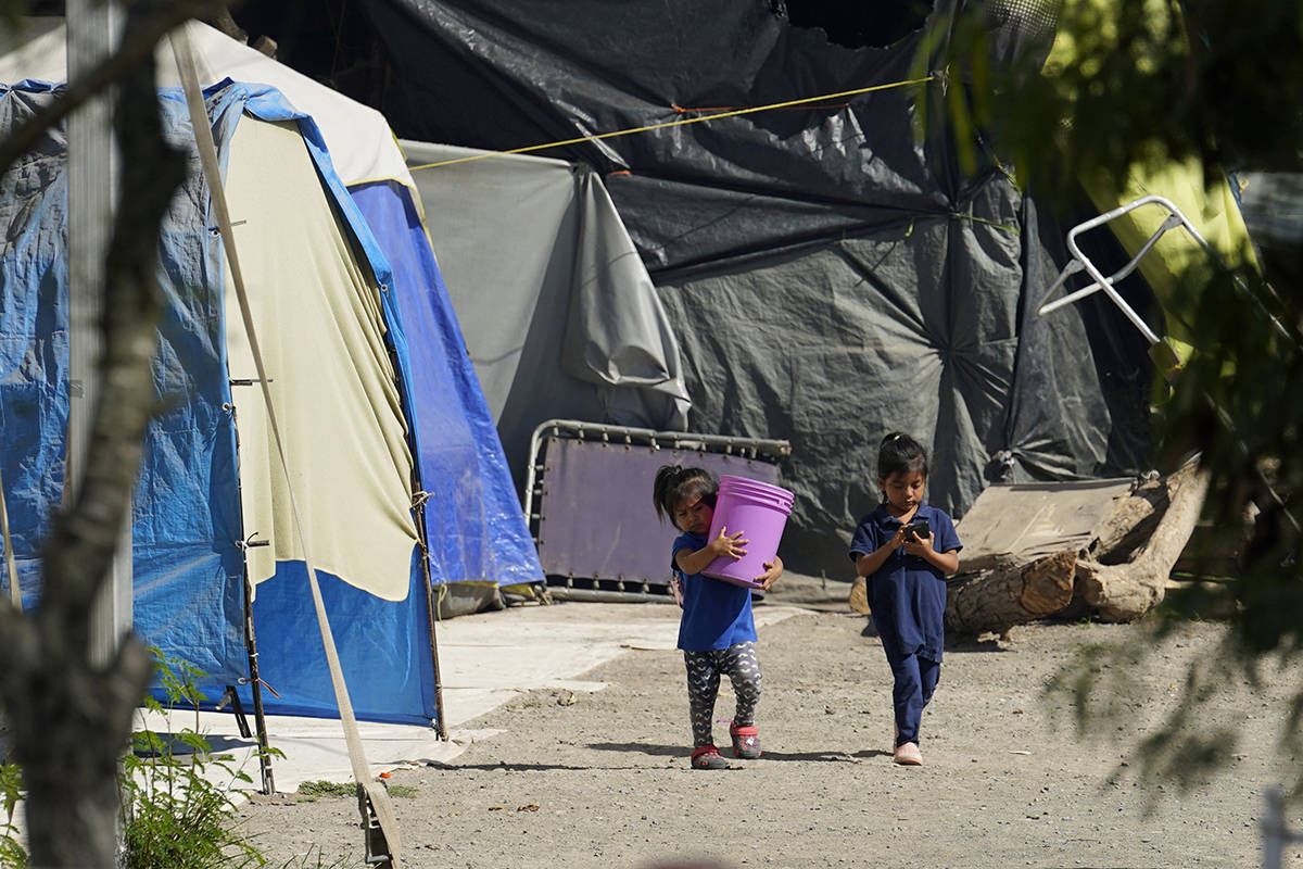 Niños caminan a través de un campamento de solicitantes de asilo atrapados en la puerta de Es ...