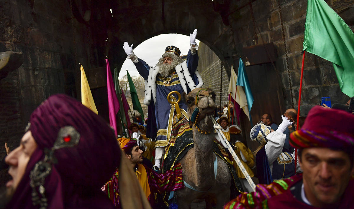 En esta foto de archivo, un rey de la cabalgata de los "Reyes Magos" saluda a la gente cuando p ...