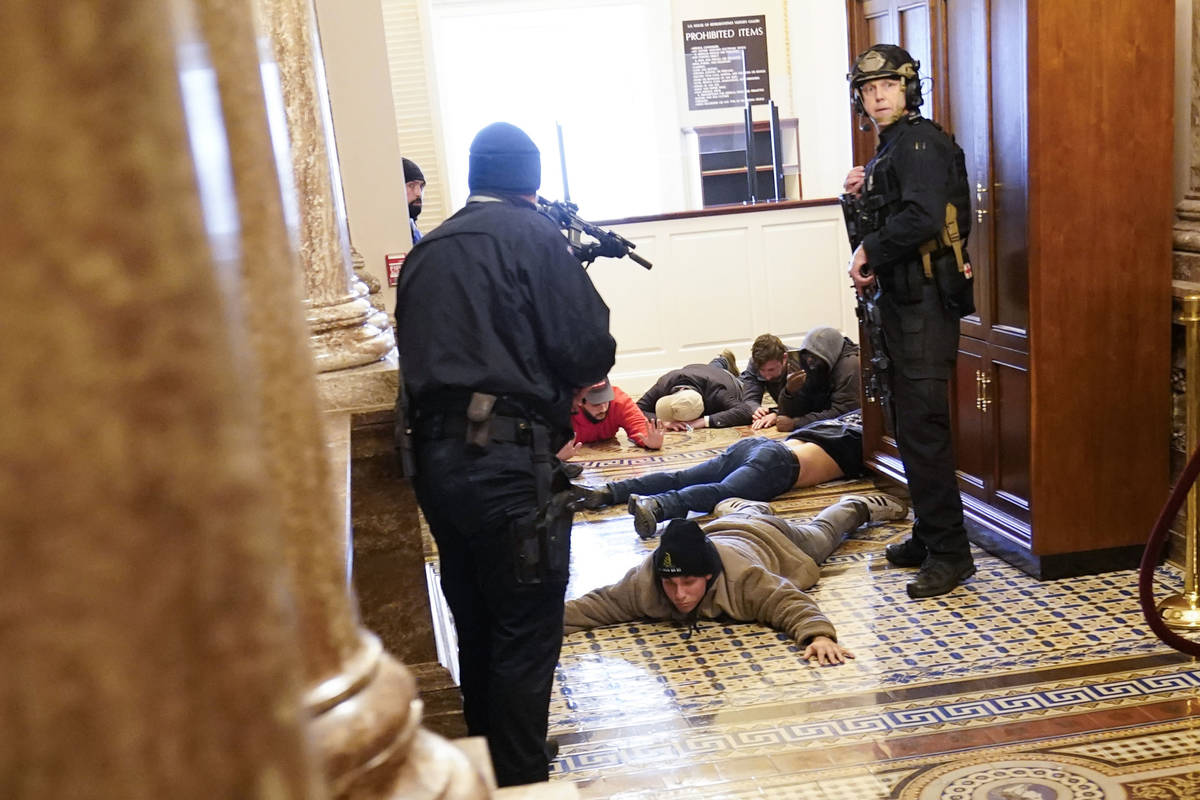 La policía del Capitolio de EE.UU. mantiene a los manifestantes a punta de pistola cerca de la ...