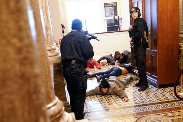 La policía del Capitolio de EE.UU. mantiene a los manifestantes a punta de pistola cerca de la ...