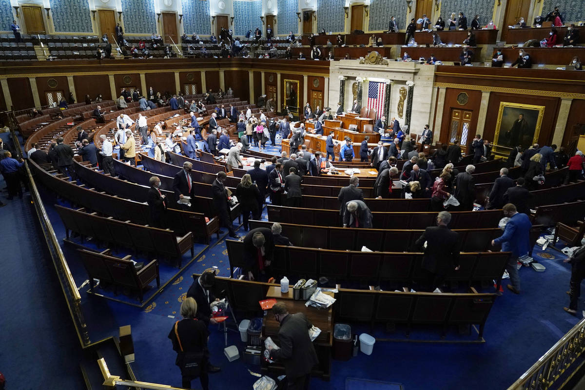 Miembros de la Cámara de Representantes se preparan para abandonar la sala mientras los manife ...