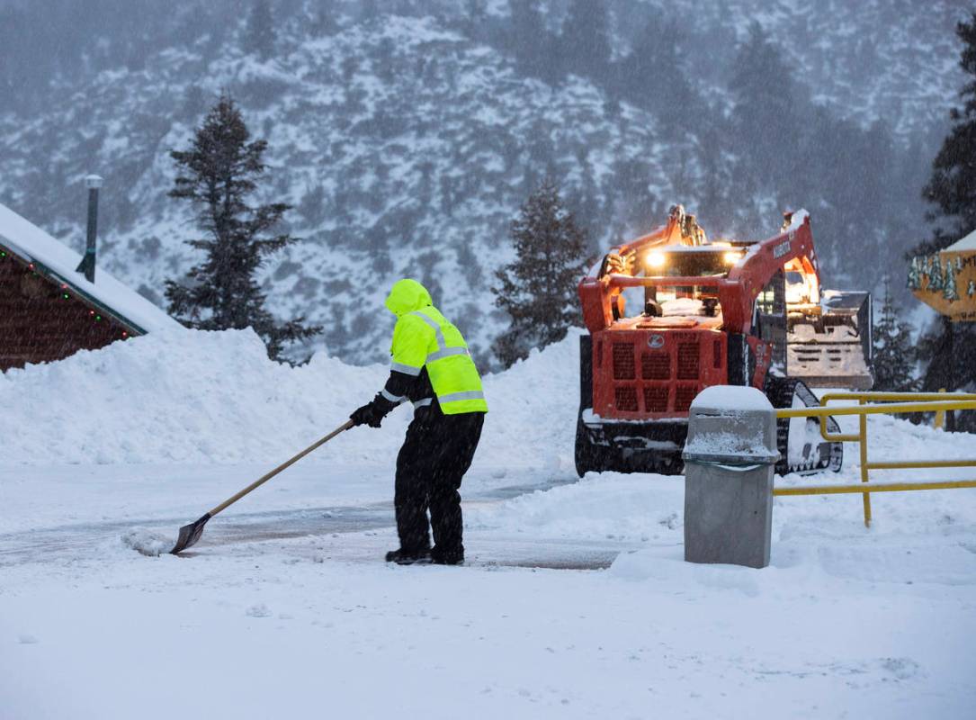 Trabajadores retiran la nieve del estacionamiento de The Charleston Lodge el lunes, 25 de enero ...