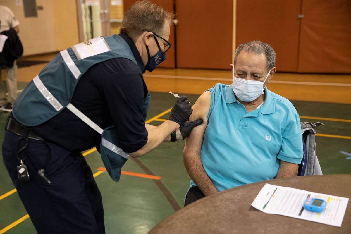 Richard Martínez, de 73 años, a la derecha, recibe la vacuna contra COVID-19 de manos de Stev ...