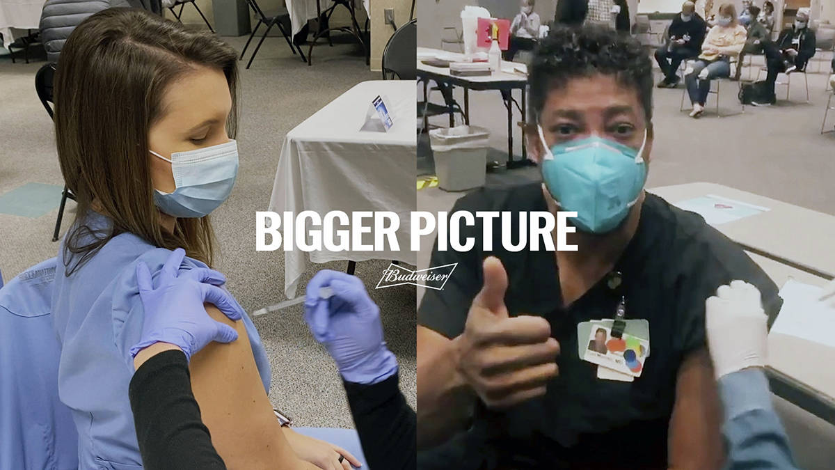 Esta imagen proporcionada por Budweiser muestra a dos trabajadores de la salud vacunándose en ...