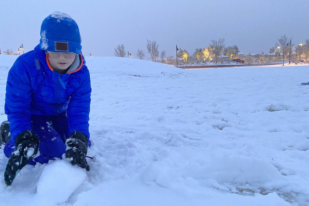 Justin Buzoff, de 13 años, construye un muñeco de nieve en el parque Fox Hills, en el extremo ...
