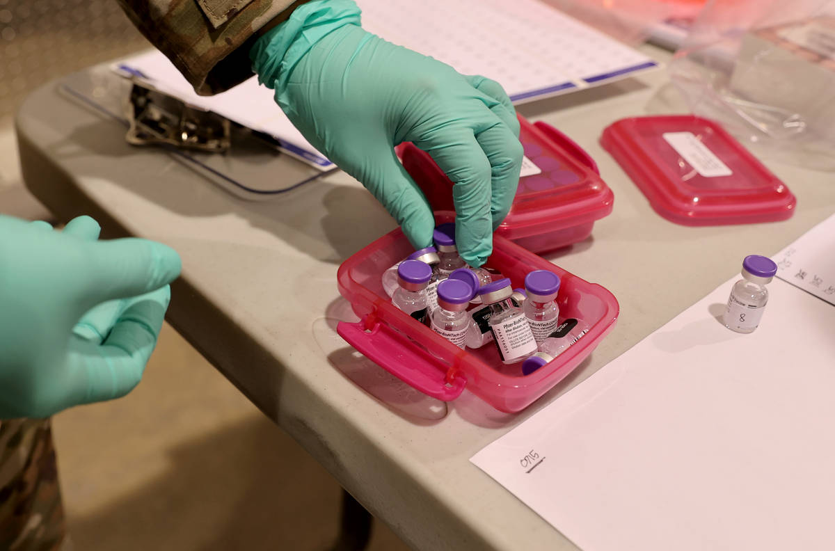 El sargento de la Guardia Nacional de Nevada Candy "D.T." Delatorre prepara la vacuna de Pfizer ...