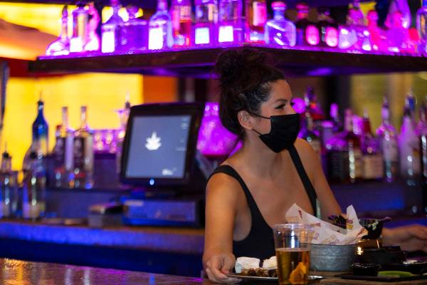 La bartender Elise Gift lleva un cubrebocas para evitar el contagio del coronavirus mientras tr ...