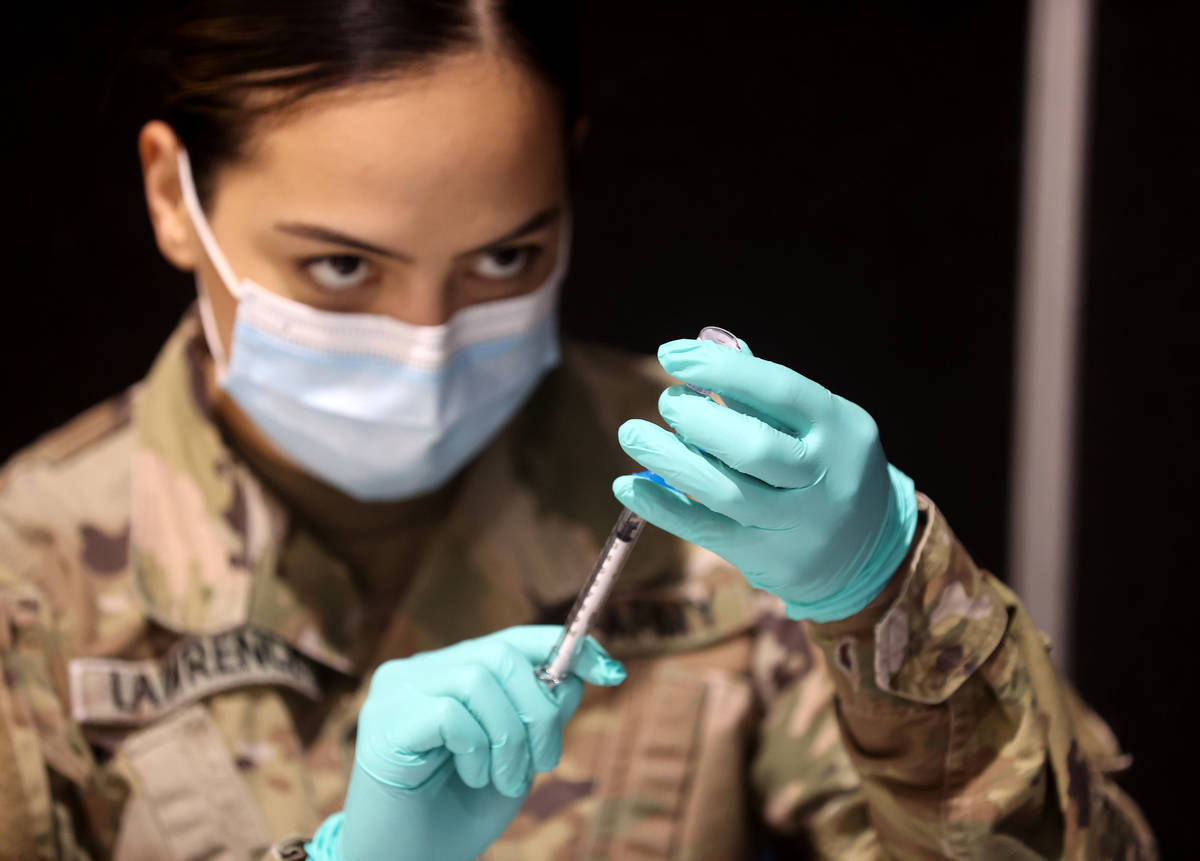 La soldado de la Guardia Nacional de Nevada, Jessica Lawrence, prepara las vacunas de Pfizer en ...