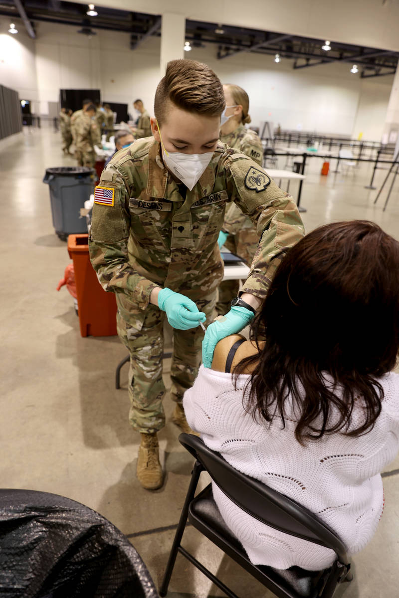 La soldado de la Guardia Nacional de Nevada, Katherine Deskins, administra la vacuna de Pfizer ...