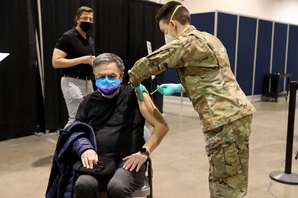 La soldado de la Guardia Nacional de Nevada, Katherine Deskins, administra la vacuna de Pfizer ...