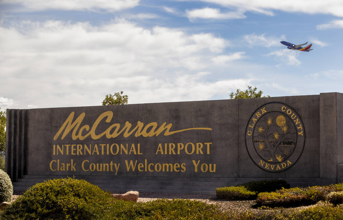Letrero del Aeropuerto Internacional McCarran con un avión despegando arriba en Tropicana Aven ...
