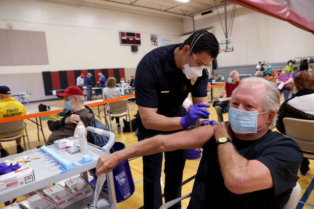 El bombero del Departamento de Bomberos de Las Vegas, Enrique López, vacuna a David Belding, d ...