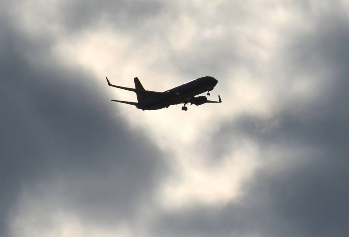 Un avión de Sun Country Airlines vuela bajo un cielo nublado mientras se acerca al Aeropuerto ...