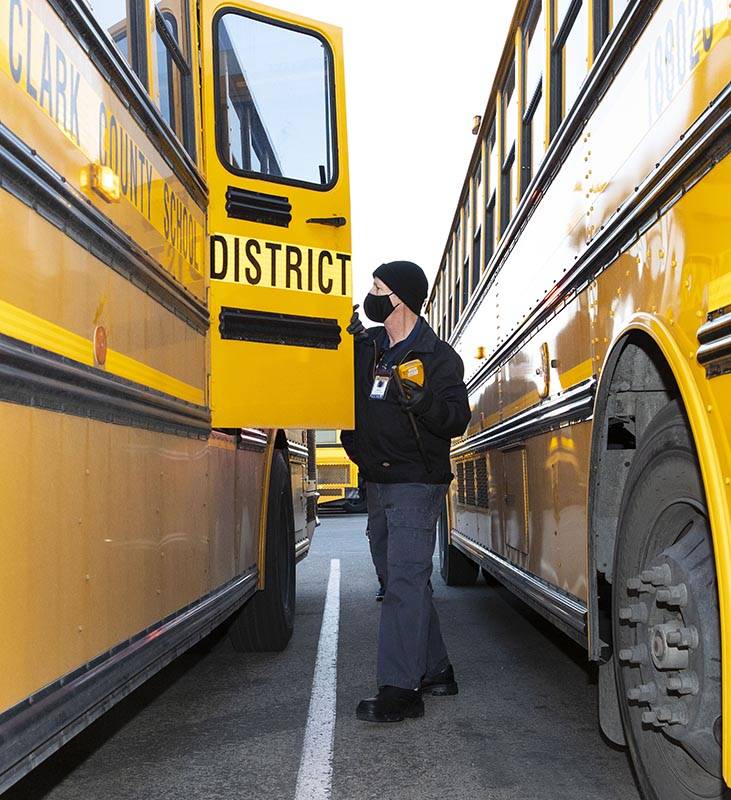Donald Brace, un conductor de autobús escolar, inspecciona su autobús mientras se prepara par ...