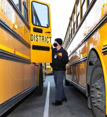 Donald Brace, un conductor de autobús escolar, inspecciona su autobús mientras se prepara par ...
