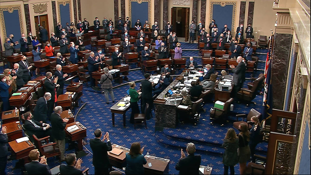 En esta imagen de un video, los senadores se ponen de pie y aplauden al personal de apoyo, ante ...