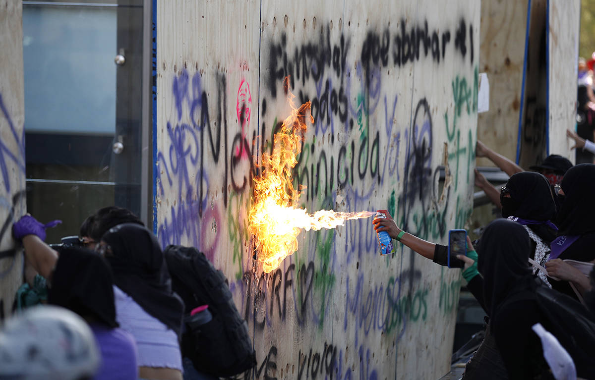 Mujeres atacan el Monumento a la Revolución de México durante una marcha para conmemorar el D ...