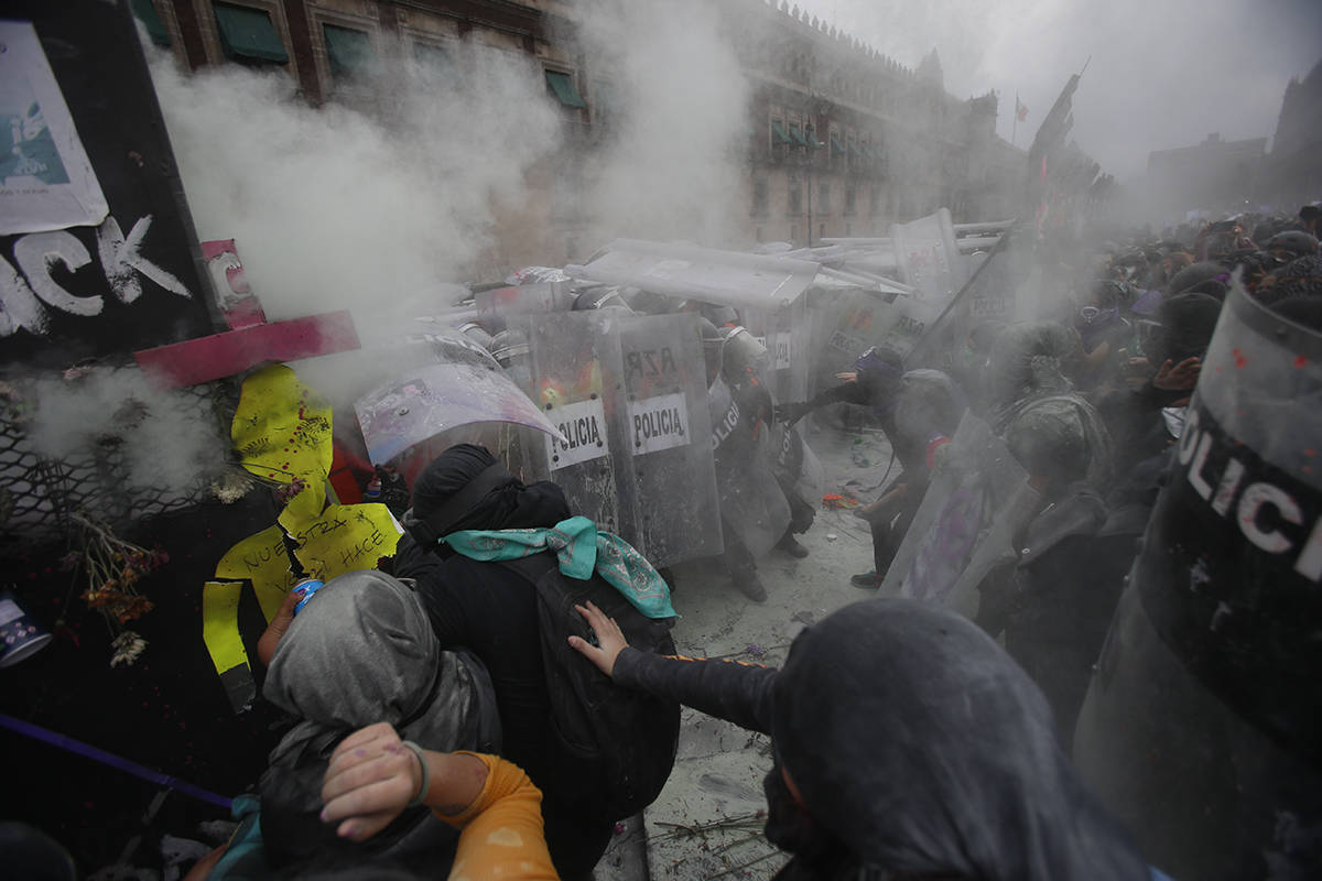 Manifestantes chocan con la policía en una brecha en una barricada que protege el Palacio Naci ...