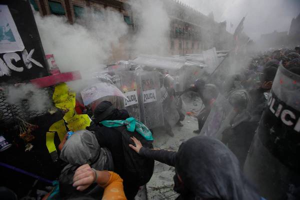 Manifestantes chocan con la policía en una brecha en una barricada que protege el Palacio Naci ...