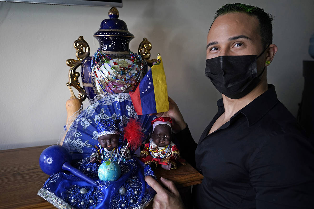 El inmigrante y peluquero venezolano Gustavo Acosta, de 36 años, posa con una bandera venezola ...