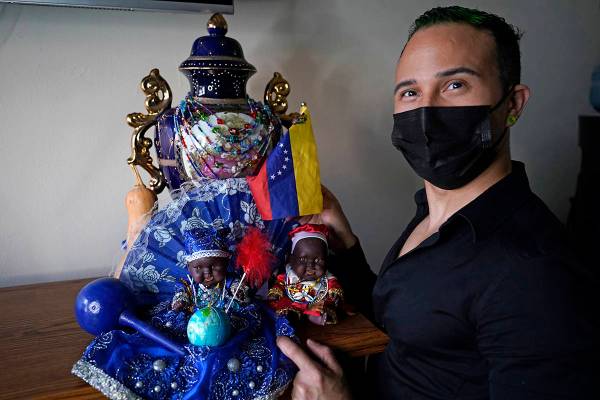 El inmigrante y peluquero venezolano Gustavo Acosta, de 36 años, posa con una bandera venezola ...