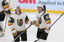 Dylan Coghlan (52), de los Vegas Golden Knights, sonríe con su compañero Shea Theodore (27) d ...