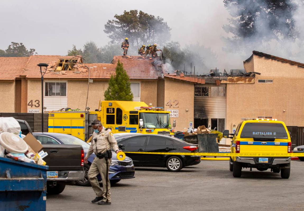 Los bomberos del Condado Clark y del Las Vegas Fire Department trabajan en la escena del Buildi ...