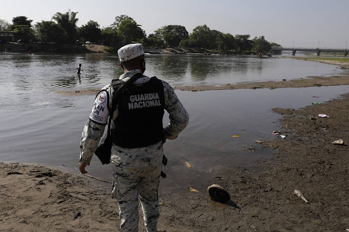 Un miembro de la Guardia Nacional Mexicana se encuentra en la orilla del río Suchiate, la fron ...