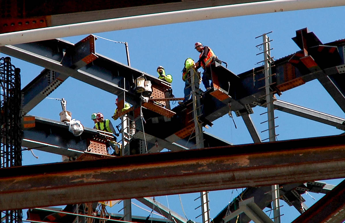 Los trabajadores hacen coincidir una viga de techo de 100 toneladas con el anillo de compresió ...
