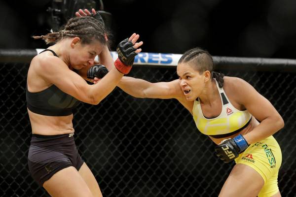 Amanda Nunes, a la derecha, golpea a Miesha Tate durante su combate por el campeonato femenino ...